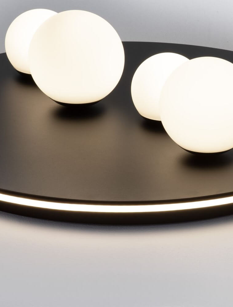 Velna LED Deckenleuchte 4-flammig Ø 62,2cm 3000K Schwarz mit Glaskugeln auf schwarzem Untergrund.
