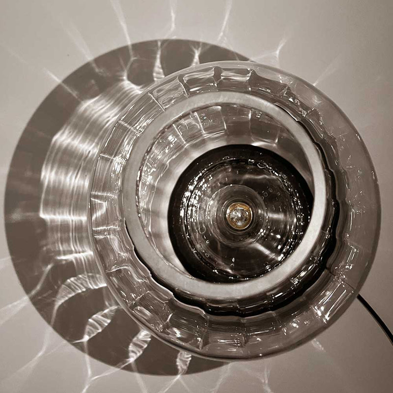 Elegante Glühbirne im Glas-Lampen-Schirm mit einzigartigen Lichtreflexionen.