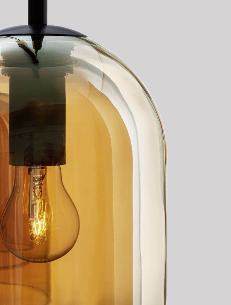 Detailansicht der Velor Pendelleuchte mit bernsteinfarbenem Glasschirm und E27 Glühlampe.