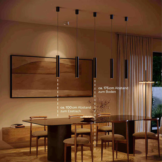 Moderne Esszimmerlampe mit fünf hängenden Leuchten über einem runden Tisch, stilvolles Interieur und angenehme Beleuchtung.