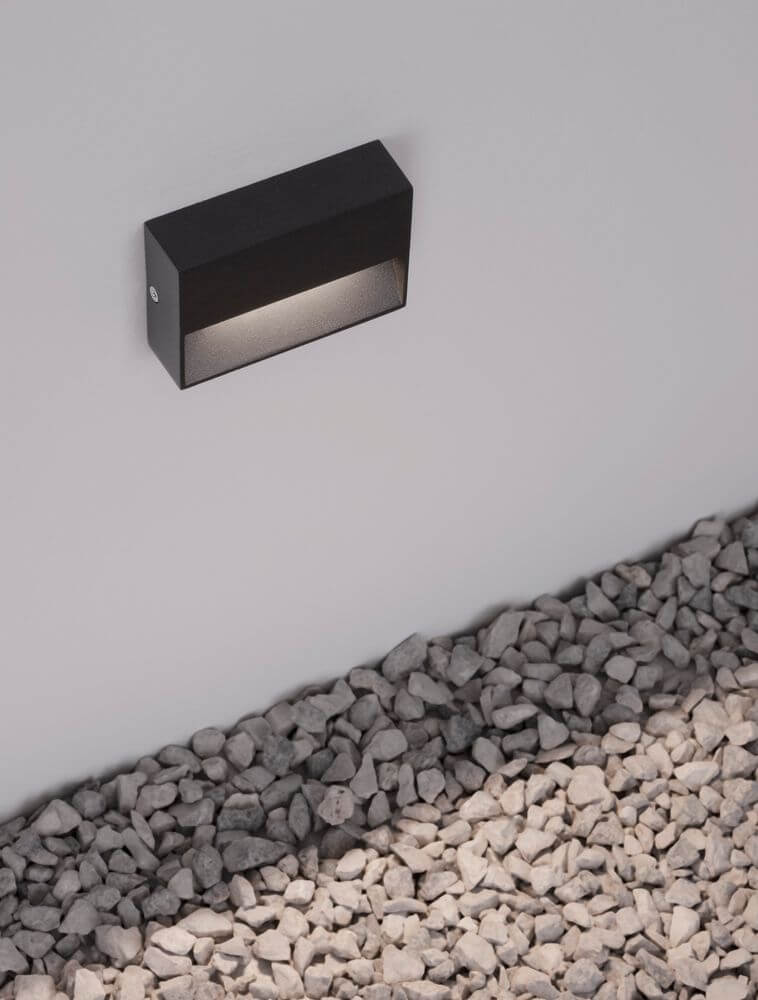 Vision LED Außenwandleuchte 3000K Anthrazit IP54 an einer Wand installiert mit Kiesuntergrund.