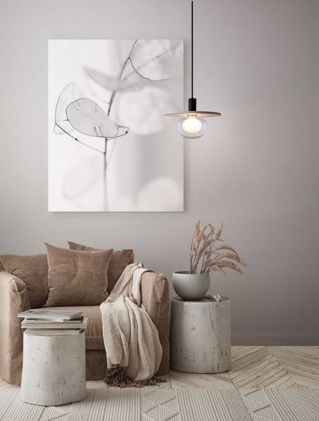 Salon élégant avec suspension Vrahos G9 Ø 29,5 cm béton beige au-dessus d’un canapé et de décorations.