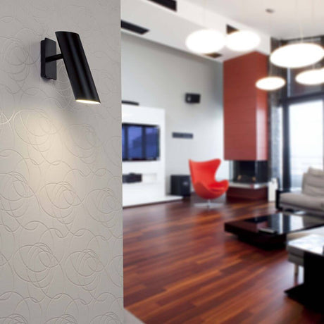 Wandlampe LINK Schwarz an einer modernen Wand in stilvollem Wohnzimmer mit Holzfußboden und eleganten Möbeln.