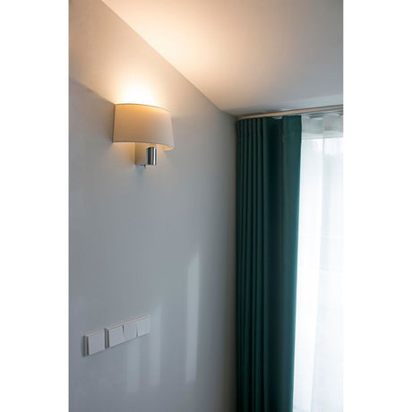 Wandleuchte HOTEL Chrom, Weiß an der Wand mit grünen Vorhängen und sanfter Beleuchtung.