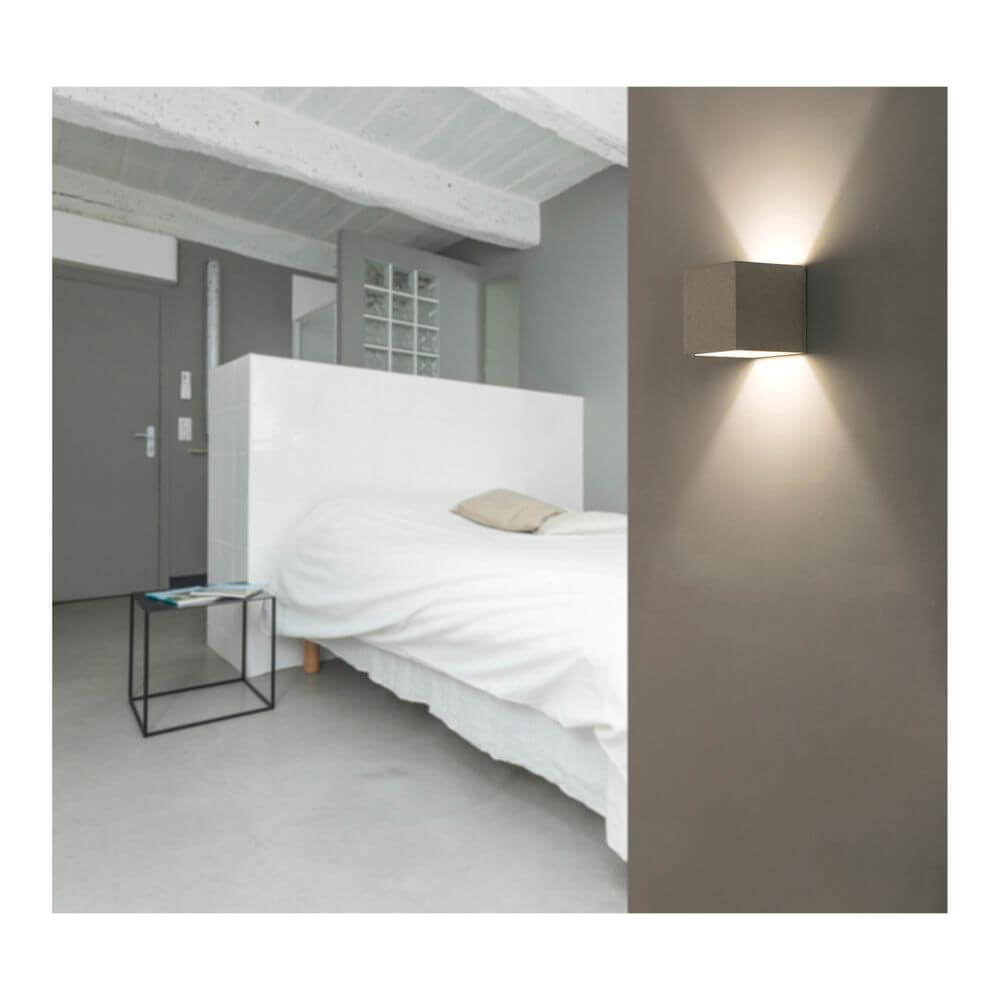 Wandleuchte KAMEN Betonoptik an einer Wand in einem modernen Schlafzimmer.