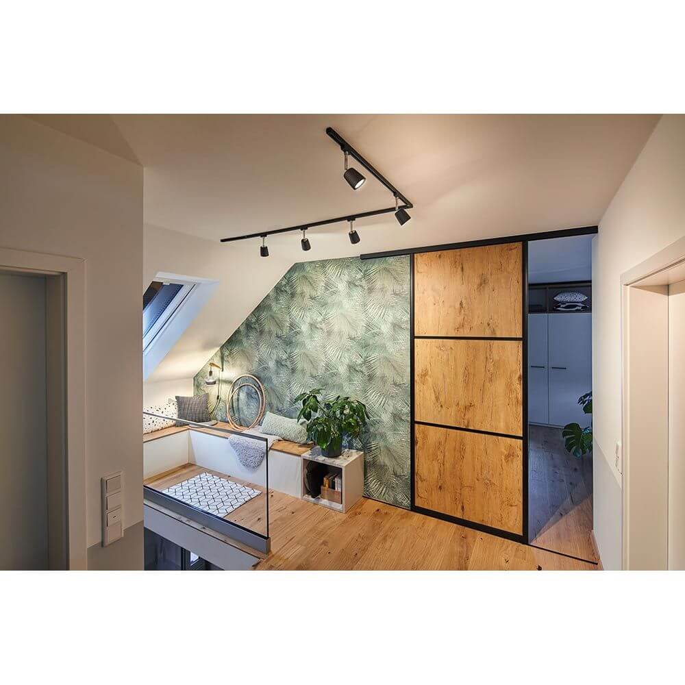 Stylisches Zimmer mit Holzmöbeln und Pflanzen, ideal für Wandlampen wie die Kian Dimmbar.