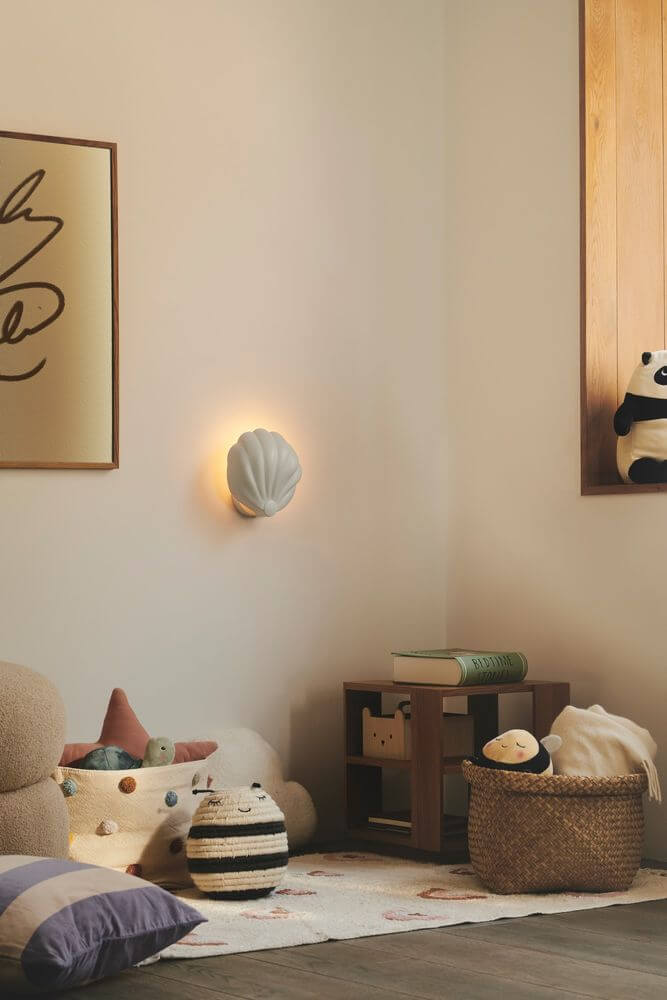 Wandleuchte Konchi in Form einer Muschel an der Wand, sanftes Licht im gemütlichen Raum.
