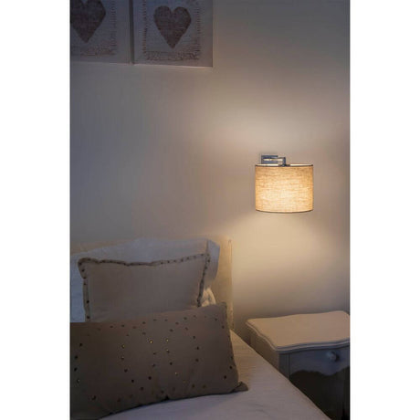 Wandleuchte SAHARA mit Schirm Chrom beleuchtet neben einem Bett in einem gemütlichen Schlafzimmer.