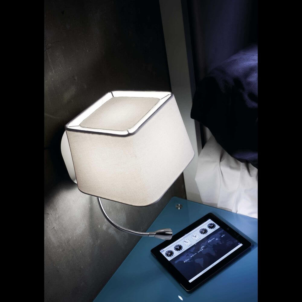 Wandleuchte SWEET mit LED-Lesearm Weiß über einem Nachttisch mit Tablet.