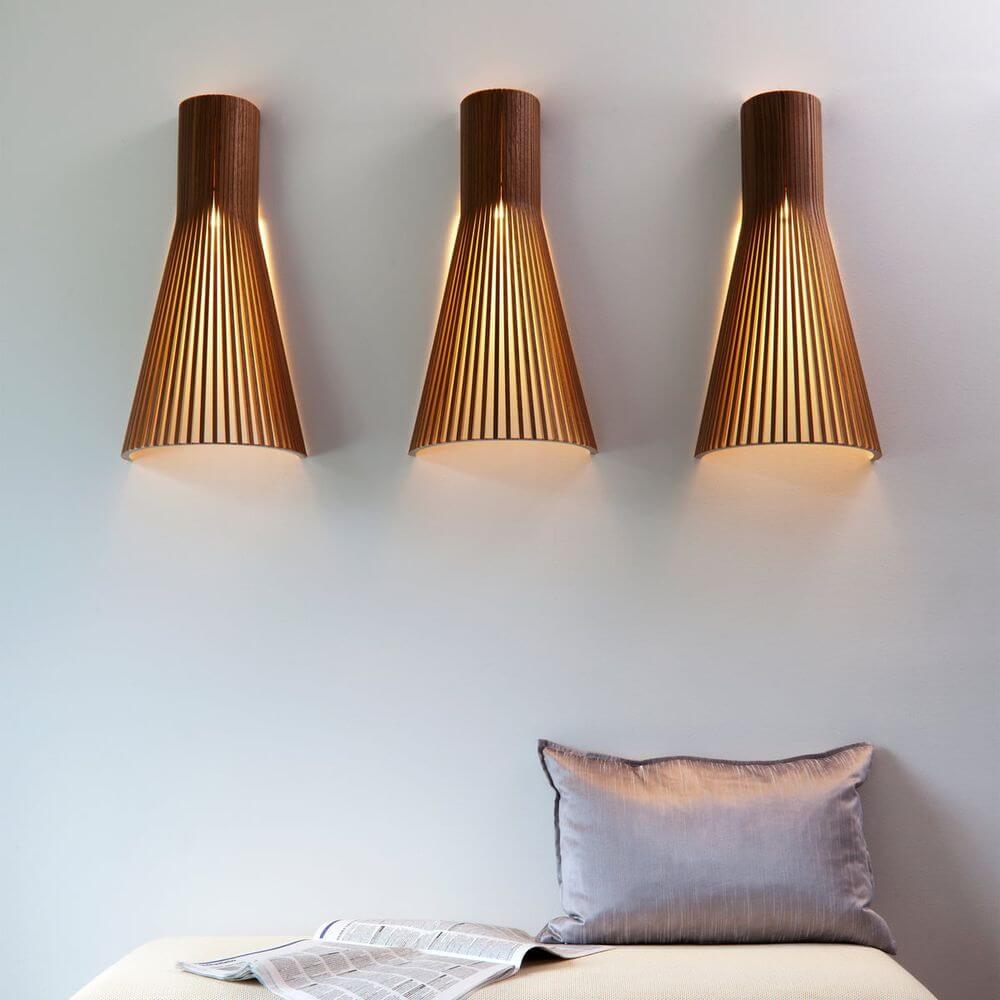 Wandleuchte Secto 4230 aus Holz 60cm, elegante Holz-Wandleuchten in konischem Design an einer Wand.