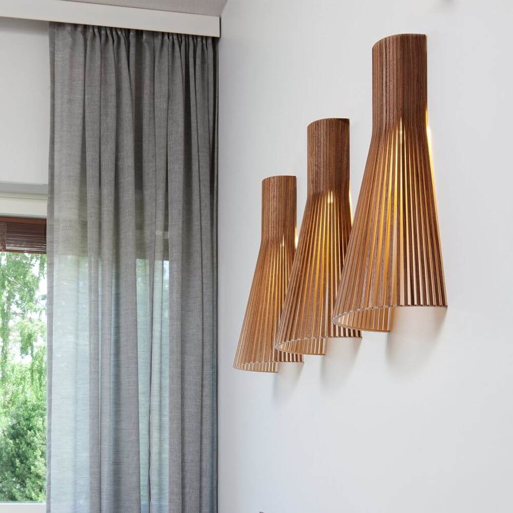 Wandleuchte Secto 4230 aus Holz 60cm im modernen Raum mit drei Leuchten an der Wand montiert.