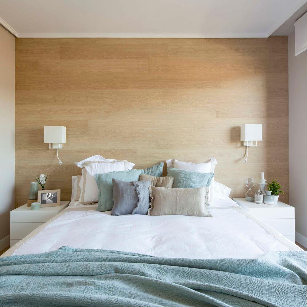 Wandleuchte VESPER mit LED-Leselampe Weiß, Beige im Schlafzimmer mit hellen Kissen und Holzverkleidung.