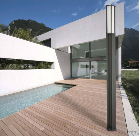 Wegeleuchte CROSS-1 IP65 Dunkelgrau beleuchtet modernen Außenbereich mit Holzterrasse und Pool.