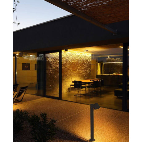 Borne lumineuse GINA 70cm IP44 gris foncé éclaire l’entrée d’une maison moderne.