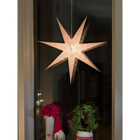 White paper star perforated with red printed pattern, 7 points, without light source, decoratively hung in the window.