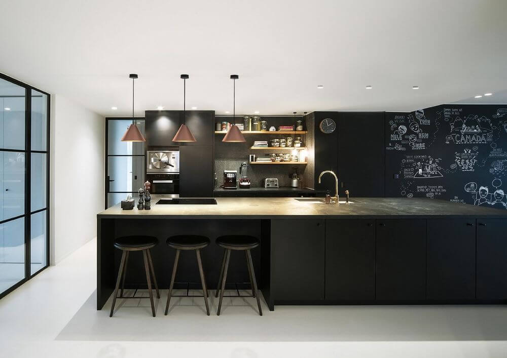 LED Hängeleuchte Shiek L in Schwarz, Goldfarben über einer modernen Küche mit schwarzem Design und offenen Regalen.