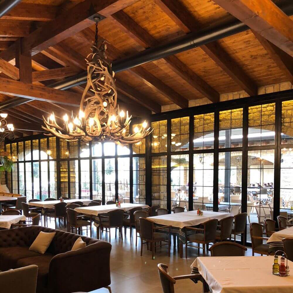 XXL Chalet Geweih Kronleuchter Ø 200cm im rustikalen Restaurant mit Holzbalkendecke