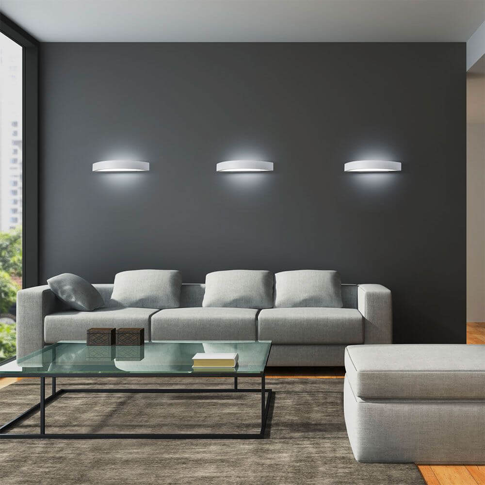Yona LED Wandleuchte 37, 5cmcm 1980lm Weiß an grauer Wand über modernem Sofa im Wohnzimmer.