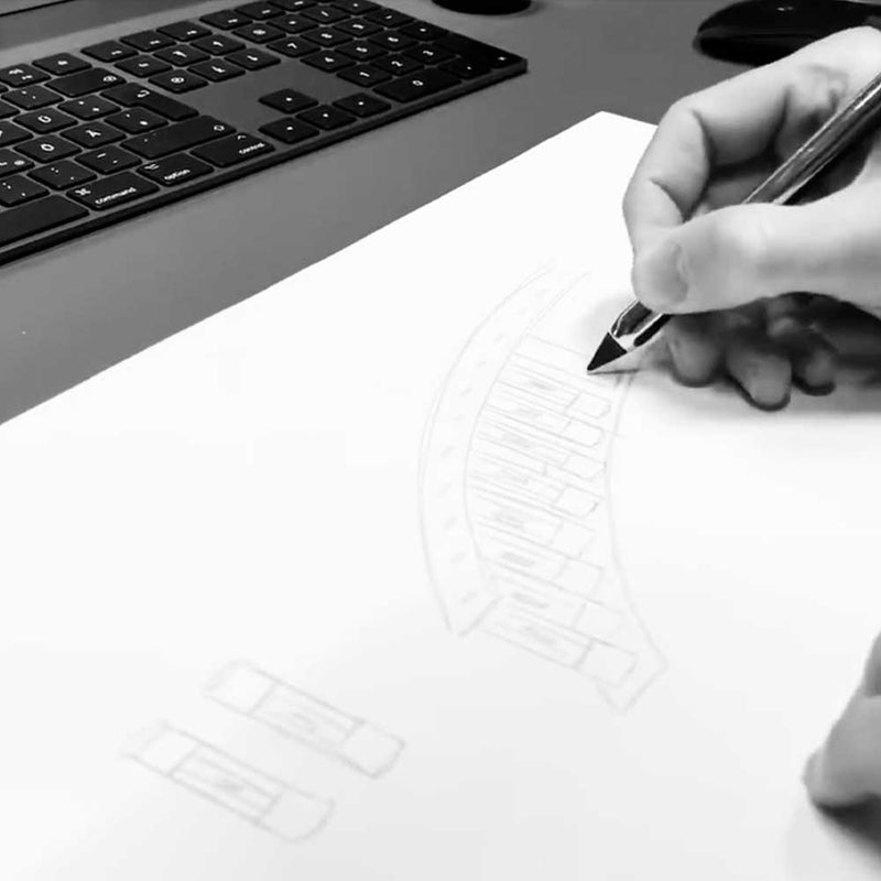 Hand skizziert Entwurf mit Bleistift auf Papier, Computer im Hintergrund.
