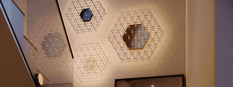 Moderne Wandleuchten in hexagonalem Design mit warmen Lichtern, die einen eleganten Raum beleuchten.