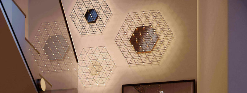 Moderne Wandleuchten in hexagonalem Design mit warmen Lichtern, die einen eleganten Raum beleuchten.