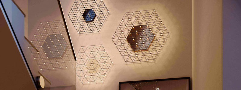 Moderne Wandleuchten in hexagonalem Design mit warmen Lichtern, die einen eleganten Raum beleuchten.