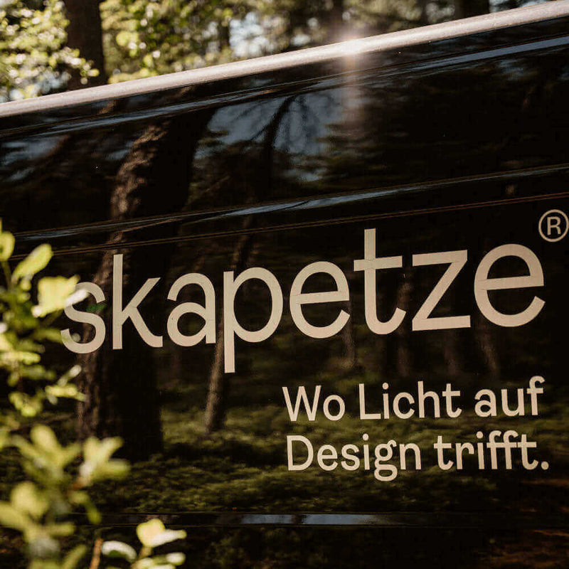 Skapetze Logo: Wo Licht auf Design trifft, auf einem Fahrzeug in der Natur.