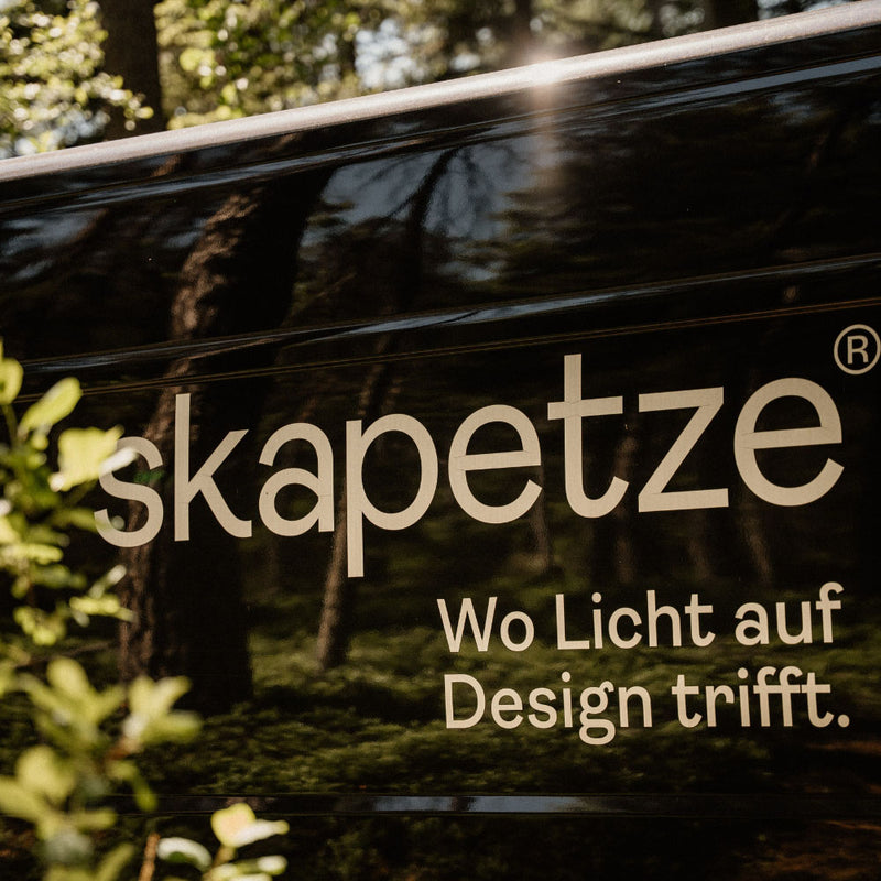 Skapetze Logo: Wo Licht auf Design trifft, auf einem Fahrzeug in der Natur.