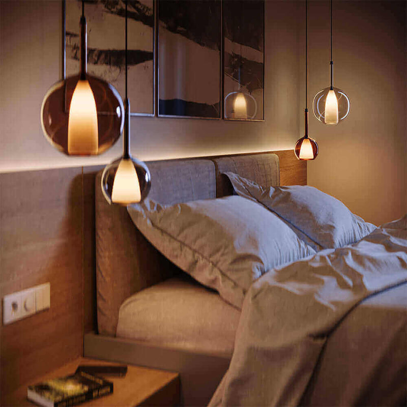 Moderne Schlafzimmerbeleuchtung mit stilvollen Pendelleuchten über einem gemütlichen Bett.
