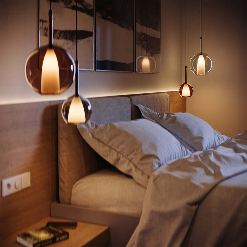 Moderne Schlafzimmerbeleuchtung mit stilvollen Pendelleuchten über einem gemütlichen Bett.