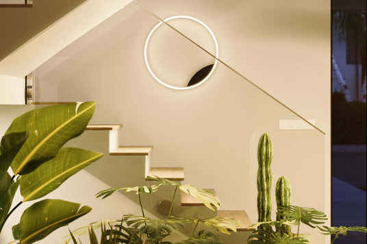 Moderne Treppe mit Pflanzen und einer kreativen Wandbeleuchtung in einem elegante Wohnraum.