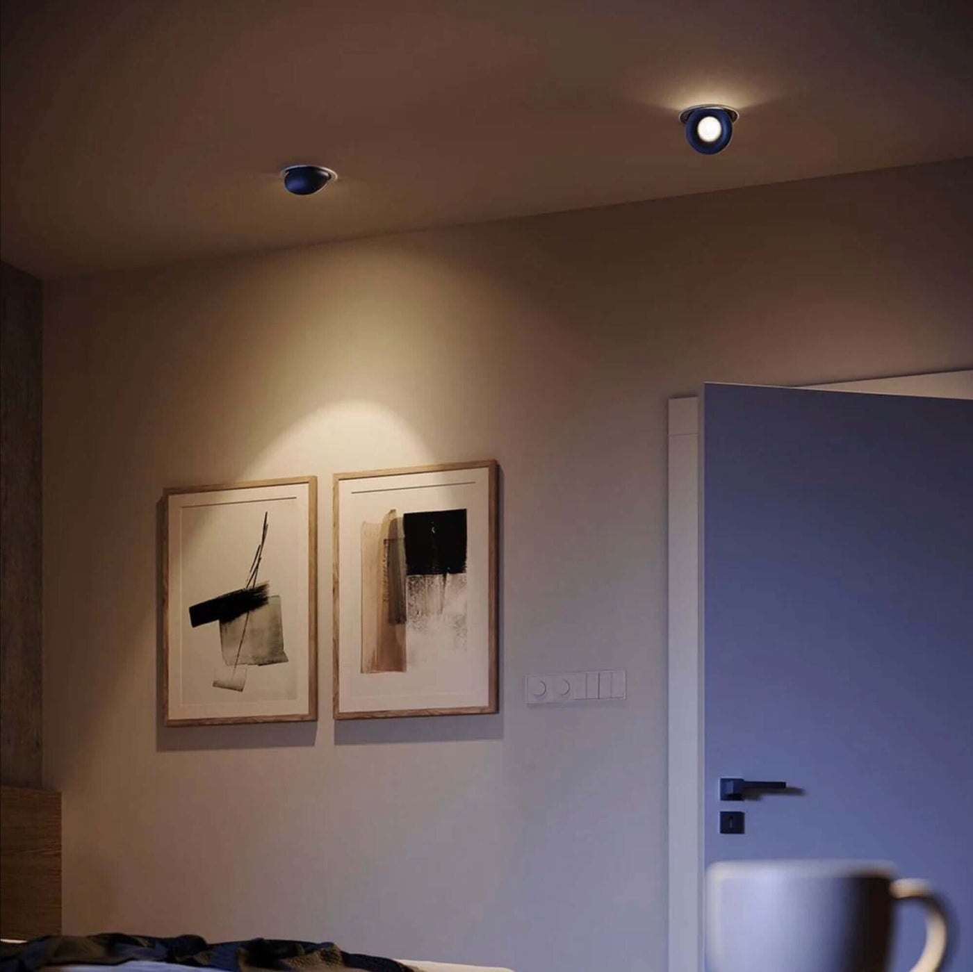 Modernes Schlafzimmer mit Spotbeleuchtung und minimalistischer Kunst an der Wand.