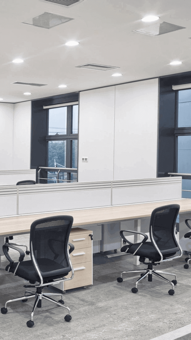 Modernes Büro mit minimalistischen Arbeitsplätzen und ergonomischen Stühlen, hell erleuchtet.