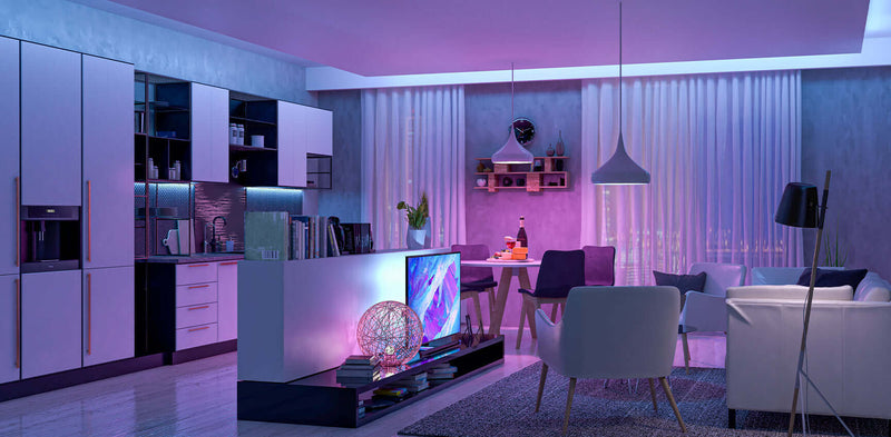 Moderne Küche und Wohnzimmer mit sanfter Beleuchtung, eleganten Möbeln und einem dekorativen Fernseher.