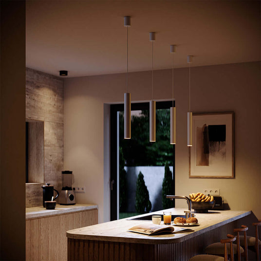 Moderne Küche mit hängenden Lampen, Holzarbeitsplatte und gemütlicher Atmosphäre, ideal für stilvolle Wohnräume.