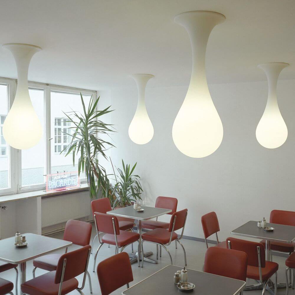 Drop-1S Deckenlampe 40cm Liquid-Light Weiß in einem modernen Café-Ambiente mit roten Stühlen.
