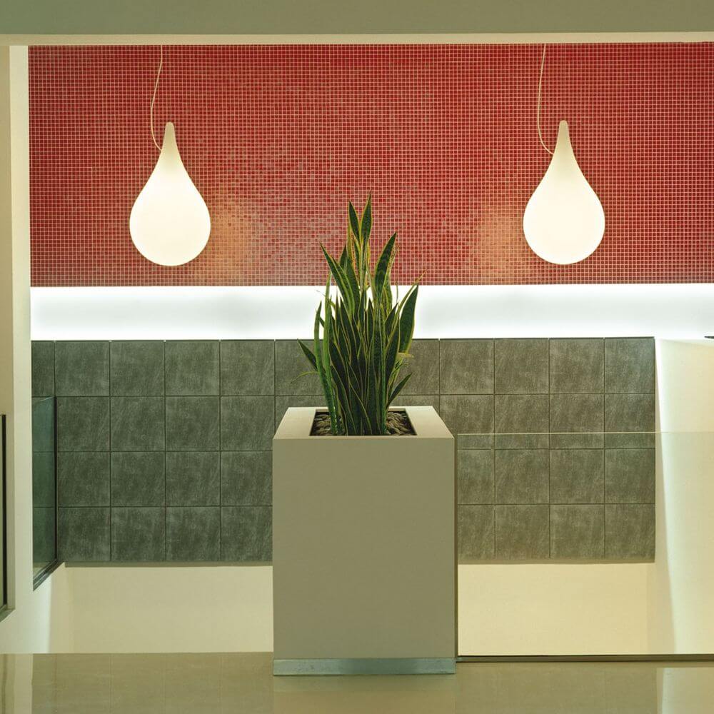 Drop-2XS LED Hängelampe Liquid-Light Weiß hängt über einer grünen Pflanze in modernem Innenraum.