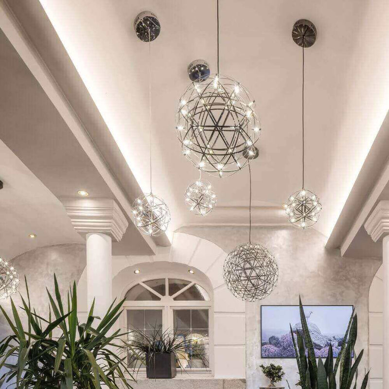 Moderne Hängeleuchten im eleganten Raumdesign mit Pflanzen und Fernseher im Hintergrund.