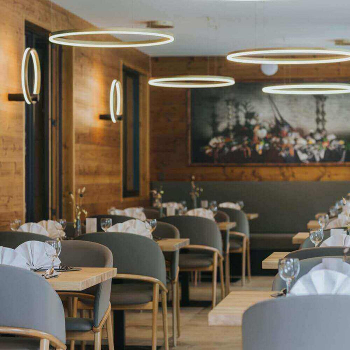 Modernes Restaurant mit eleganten runden Leuchten und stilvollen Tischen, perfekt für kulinarische Erlebnisse.