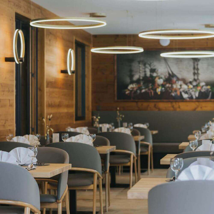 Modernes Restaurant mit eleganten runden Leuchten und stilvollen Tischen, perfekt für kulinarische Erlebnisse.