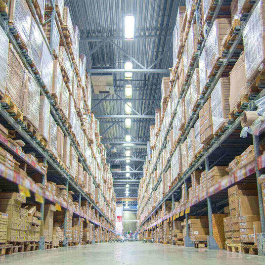 Großer Lagerraum mit hohen Regalen, gefüllt mit Verpackungen und Waren, ideal für Logistik und Lagerverwaltung.