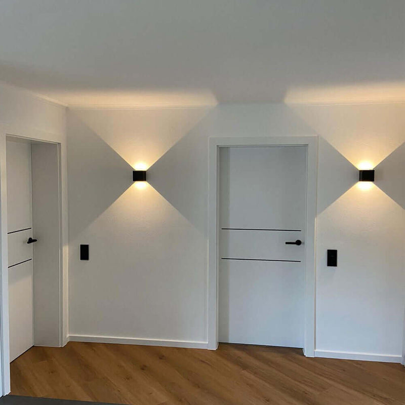 Moderne Innenräume mit zwei Türen und stilvollen Wandlampen in neutralen Farbtönen.