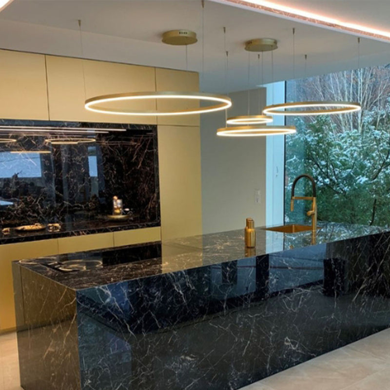 Moderne Küche mit schwarzen Marmorflächen und eleganter Beleuchtung für stilvolles Kochen.