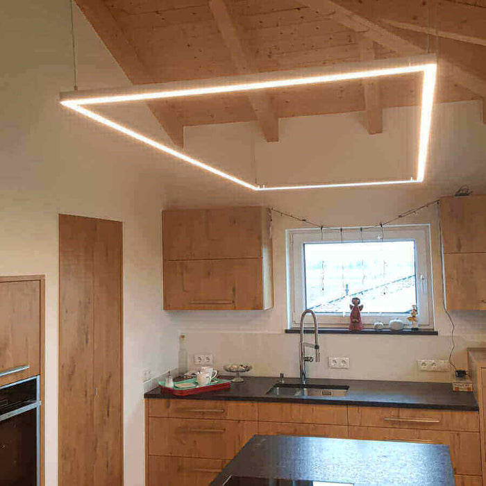 Moderne LED-Deckenleuchte in einer modernen Küche mit Holzdetails und minimalistischem Design.