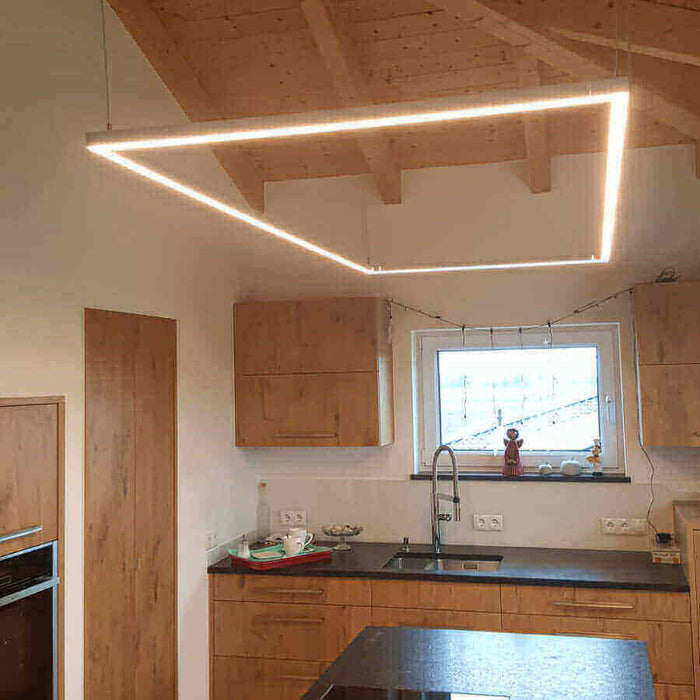 Moderne LED-Deckenleuchte in einer modernen Küche mit Holzdetails und minimalistischem Design.