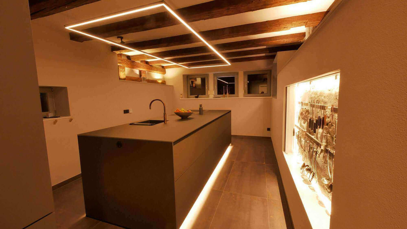 Moderne Küche mit stilvollem Design, beleuchtetem Kochinsel und Holzdecke, ideal für eine elegante Atmosphäre.