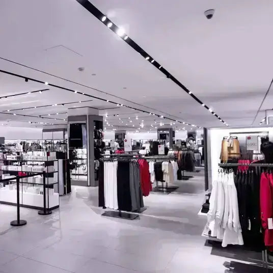 Moderner Mode-Laden mit gut beleuchteten Regalen voller Kleidung und Accessoires.