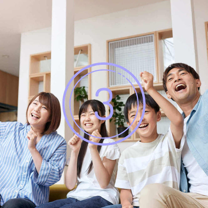 Vier fröhliche Menschen jubeln und feiern zusammen, mit der Zahl drei im Vordergrund.