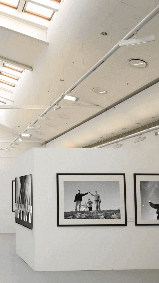 Innenansicht einer Galerie mit Schwarz-Weiß-Fotografien und moderner Architektur.