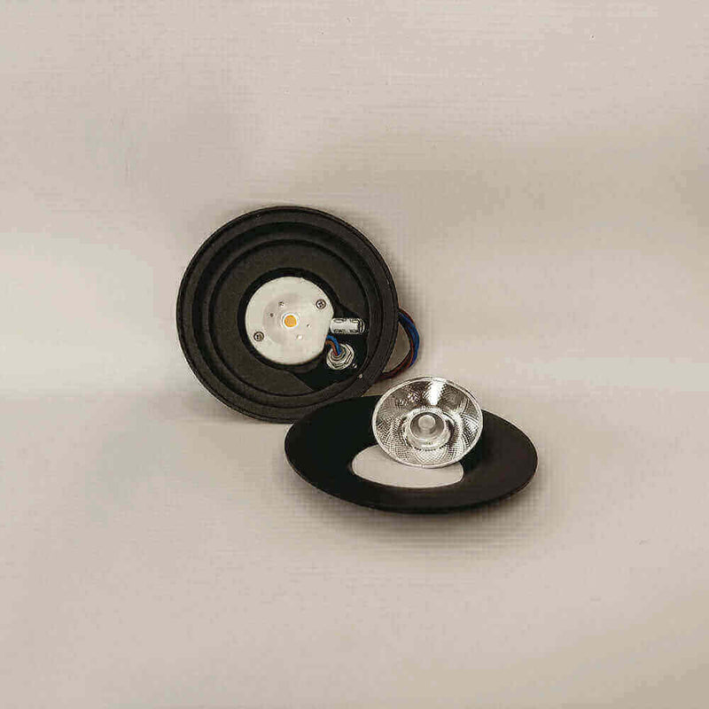 Luce Spiegelreflektor mit schwarzem Sockel und silberner Linse auf grauem Hintergrund.